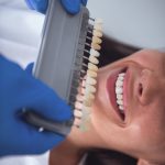 woman is sitting in dentist's chair while doctor is examining her teeth