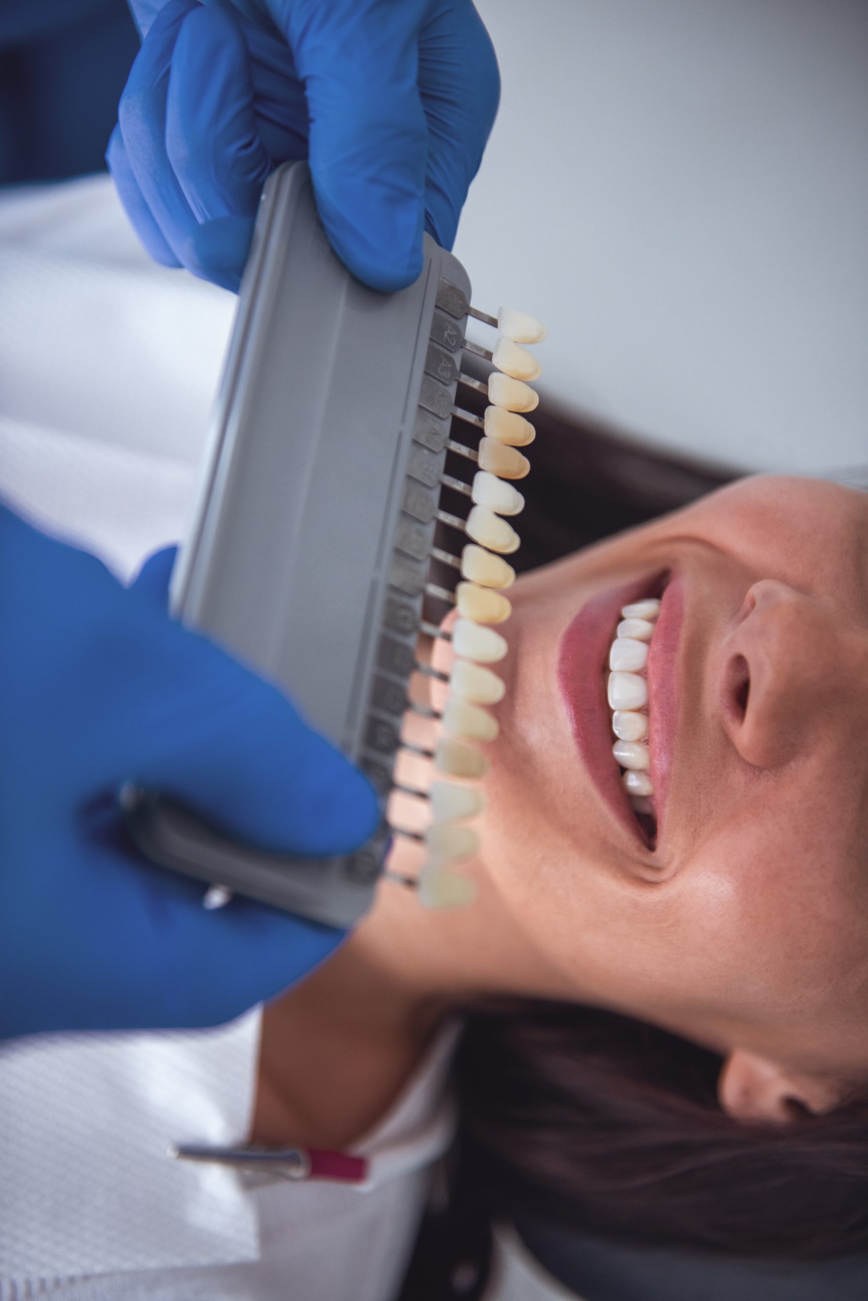 woman is sitting in dentist's chair while doctor is examining her teeth