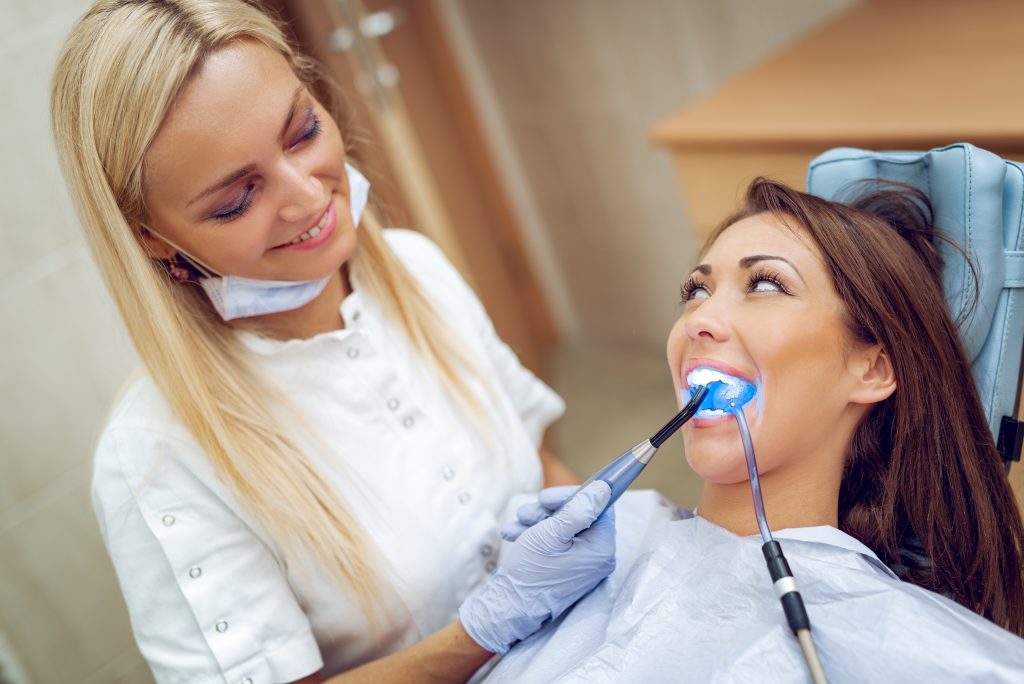 Dental professional drying a dental filling during treatment