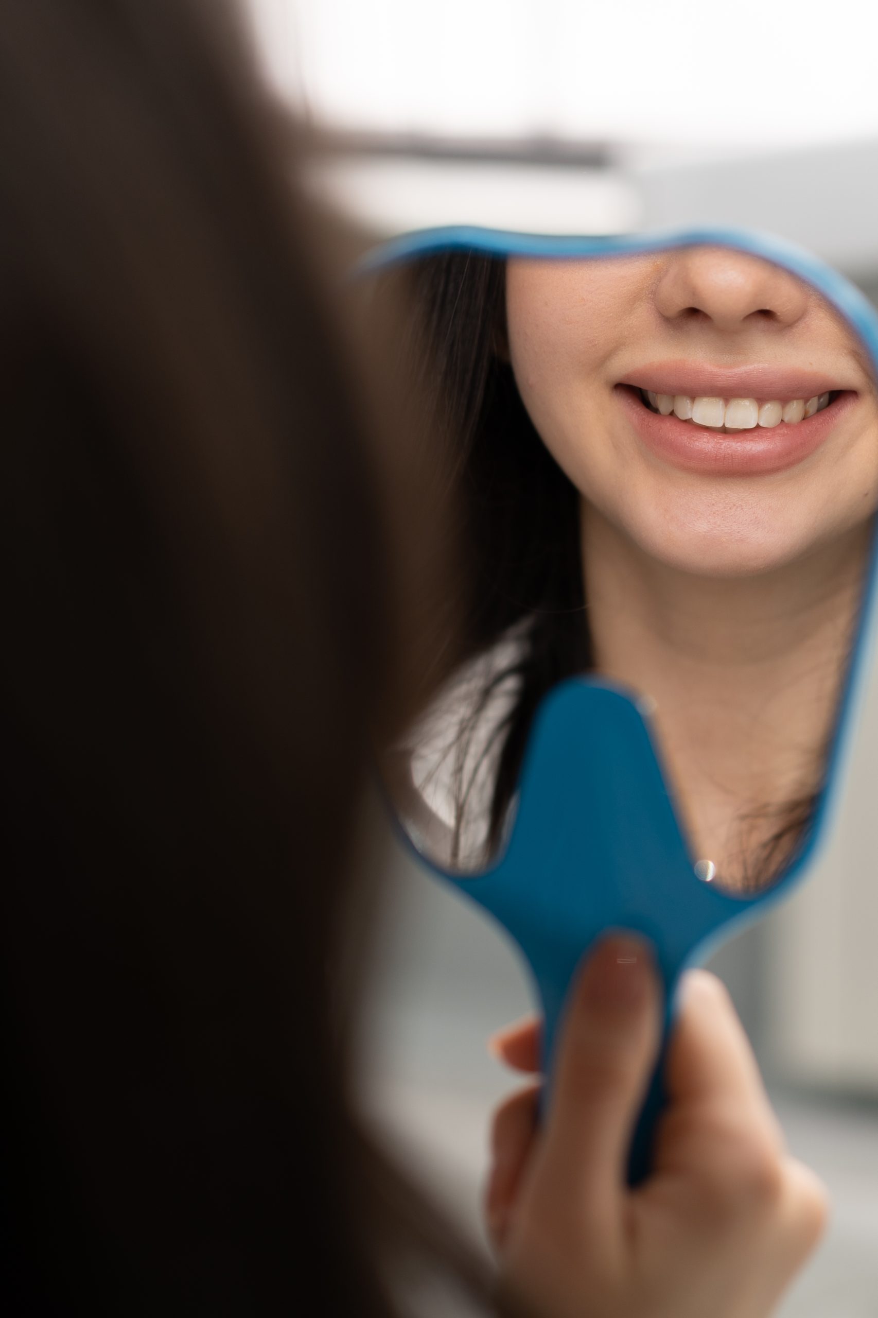 Satisfied dental patient looking in mirror