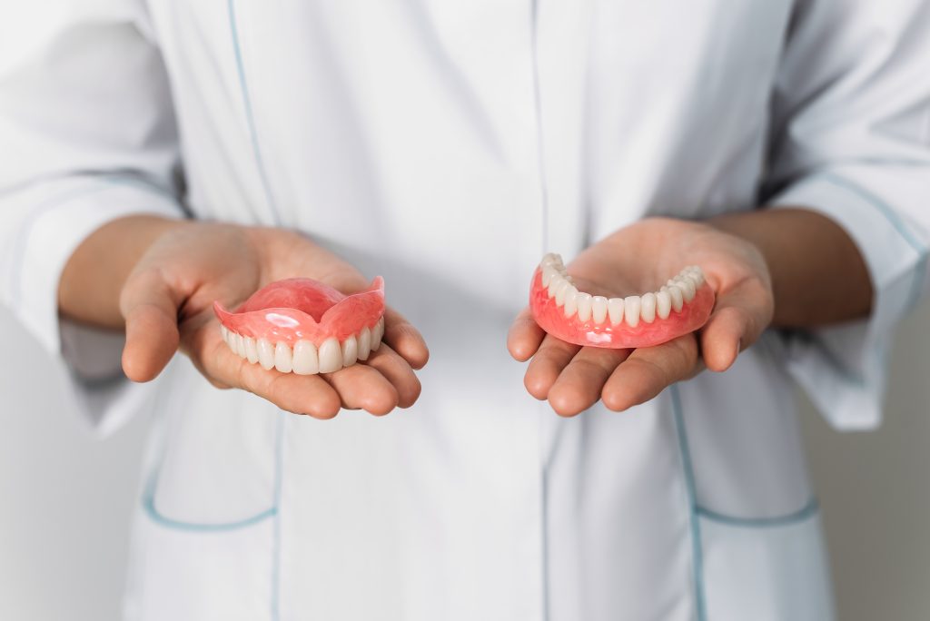 Dentist holding dentures.