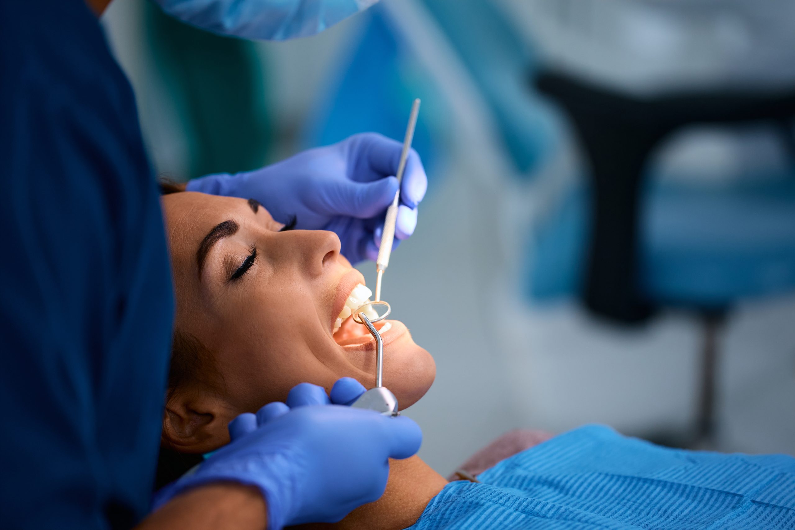 Dentist examining young woman’s teeth